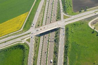 
Luftaufnahme von zwei mautpflichtigen Straßen: eine Bundesstraßen-Brücke überspannt eine Autobahn