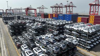 Eine Luftaufnahme zeigt chinesische Autos mit Hybrid- oder Elektroantrieb für den Export in einem chinesischen Hafen.