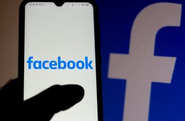 hand hält Smartphone mit Facebook auf dem Bildschirm mit Facebook-Hintergrund