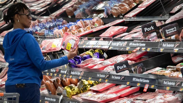 Eine Kundin in einem Supermarkt in New York, USA, betrachtet kritisch eine Packung mit Fleisch